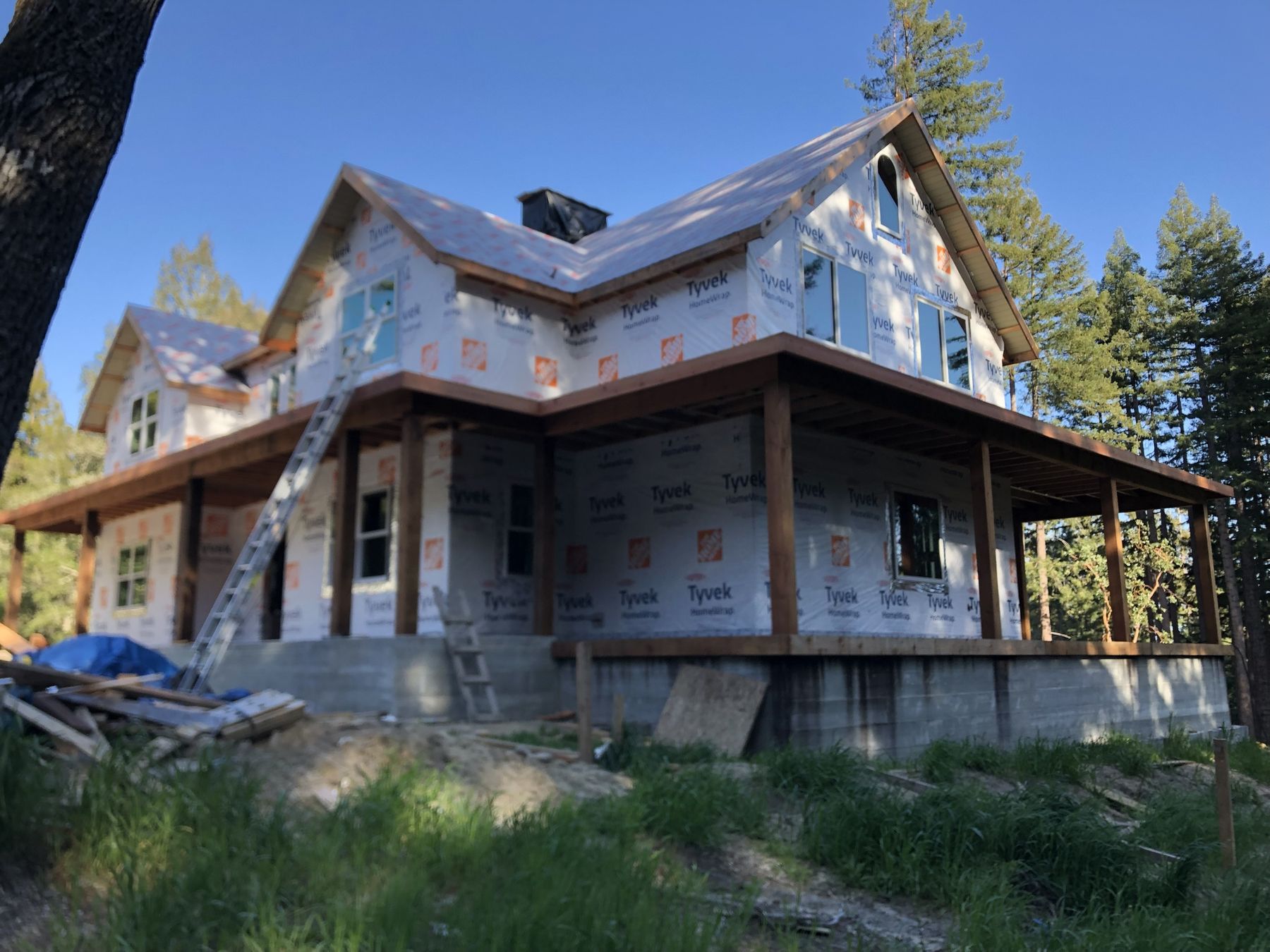 New home wrapped in house wrap with wrap-around porch