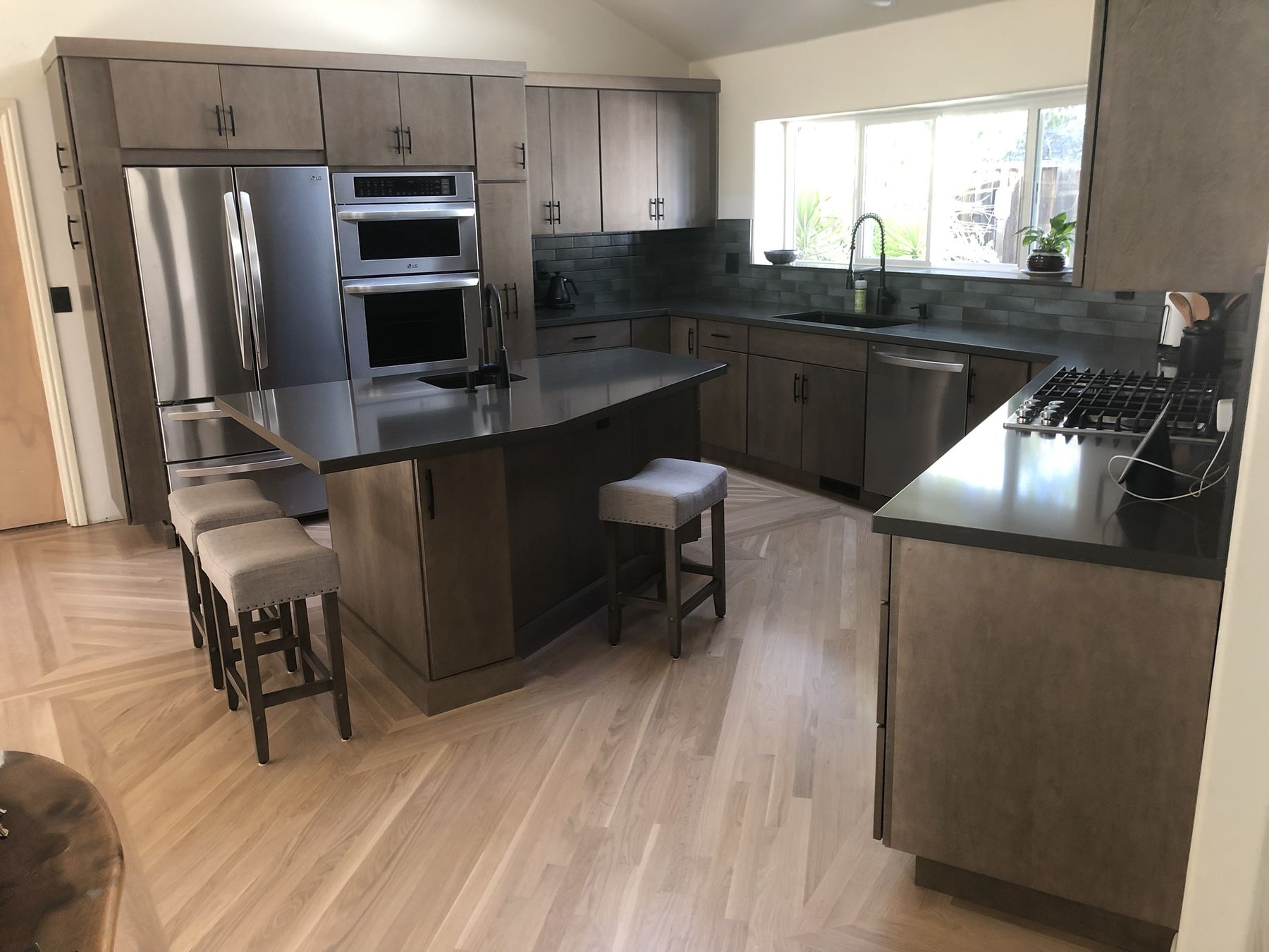 Remodeled kitchen with stained maple cabinets, quartz counters and hardwood floors