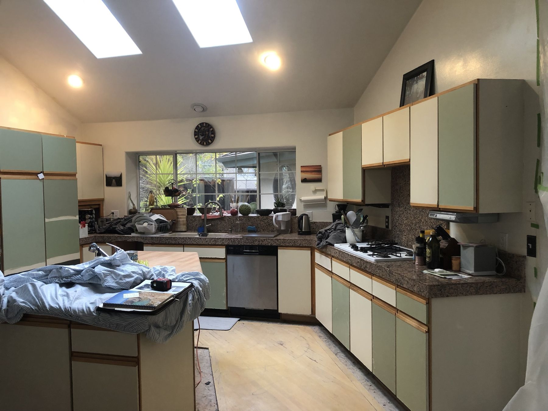 Dated kitchen with green laminate cabinets before remodel
